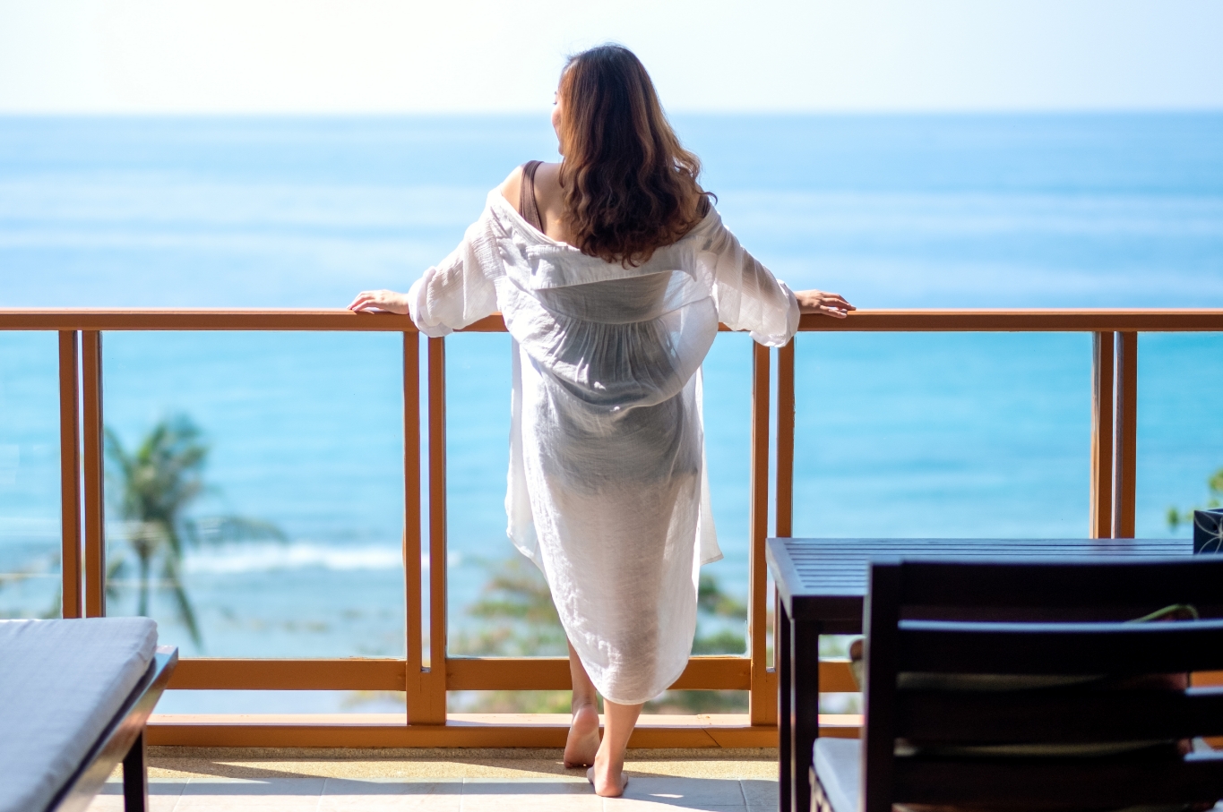 Woman overlooking water from a balcony