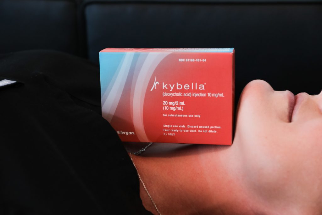 Kybella box resting on a woman's neck and chin