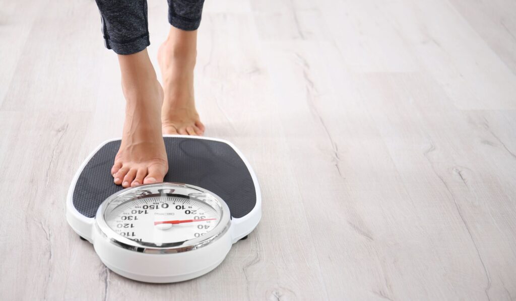 Photo of a woman stepping on a scale